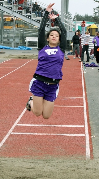 Janessa Ramos soars in the long jump as teammate Shantae Young checks the takeoff board. Ramos failed to place in the event