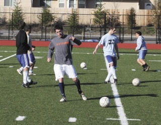Players on the Oak Harbor High School soccer team work on a ball-handling and passing drill during a preseason practice session on the turf at Wildcat Memorial Stadium.