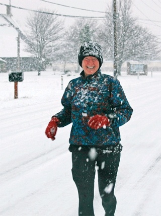 Oak Harbor resident Debbie Gallo runs down SW Third Avenue Wednesday morning. She planned to run her usual six miles despite the several inches of snow that blanketed Whidbey Island.