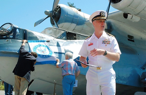 PBY Memorial Foundation members Will Stern and Win Stites secure the U.S. Navy flag onto a PBY flying boat while Naval Air Station Whidbey Island’s commanding officer