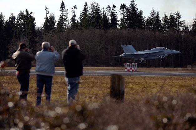 Spectators watch as an EA-18G Growler performs a touch-and-go at Outlying Field Coupeville. A community group opposed to jet noise is preparing to take legal action in hopes of reopening a 2005 environmental assessment.