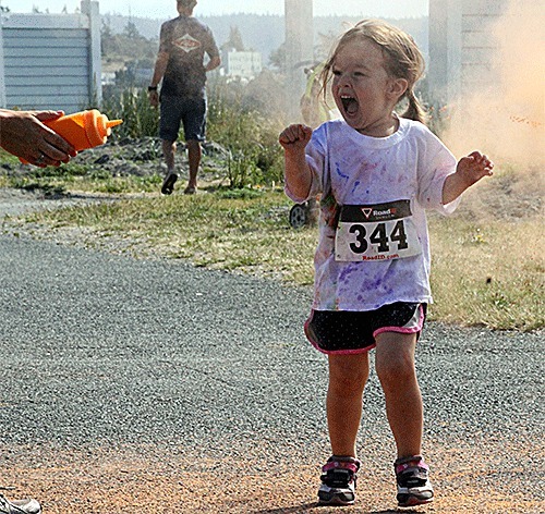 A youngster reacts to seeing a powder bottle pointed her way in Saturday's Run IN Color.