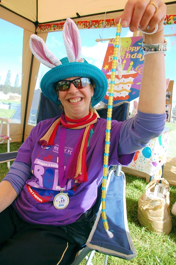 Oak Harbor resident Ginny Walters holds up a string of beads at the North Whidbey Relay for Life. Each bead represents one lap she walked around North Whidbey’s Middle School track. Walters walked 84 laps