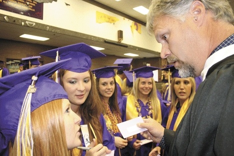 Principal Dwight Lundstrom practices enunciating Kristian Knippers and Bryanne Haun’s names before reading them on the card during the ceremony.