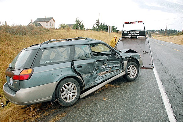 Tom Hopper of Oak Harbor A-1 Towing hoists a 2000 Subaru Outback onto a flatbed Monday morning. The vehicle was involved in a two-car wreck at the intersection of Highway 20 and Ebey Road.