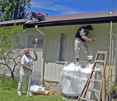Central Whidbey Hearts and Hammers volunteer Beth Tristao helps paint the exterior of a house in Coupeville during a previous spring work day.