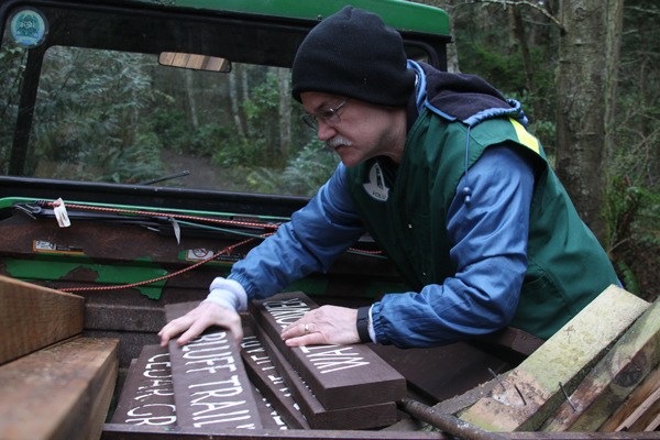 Volunteer Larry Doles sorts through new trail signs to install at Fort Ebey State Park.