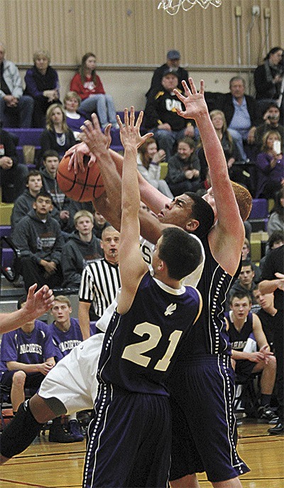 Oak Harbor's Drew Washington (white uniform) draws plenty attention from Anacortes defenders Daniel McInerney (21) and Peter Haynes. Washington led the Wildcats with 21 points in the season opener with the Seahawks.