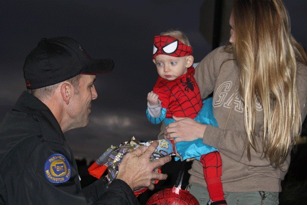 One young trick-or-treater isn’t sure what to make of Lt. Craig Anderson of the Oak Harbor Fire Department on Halloween night in downtown.