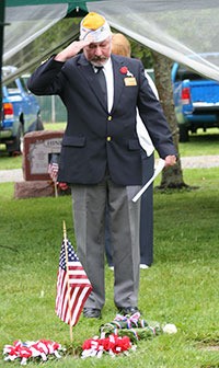 VFW Chaplain Wes Wilson reads a prayer and salutes the fallen at Monday's Memorial Day service at Maple Leaf Cemetery.
