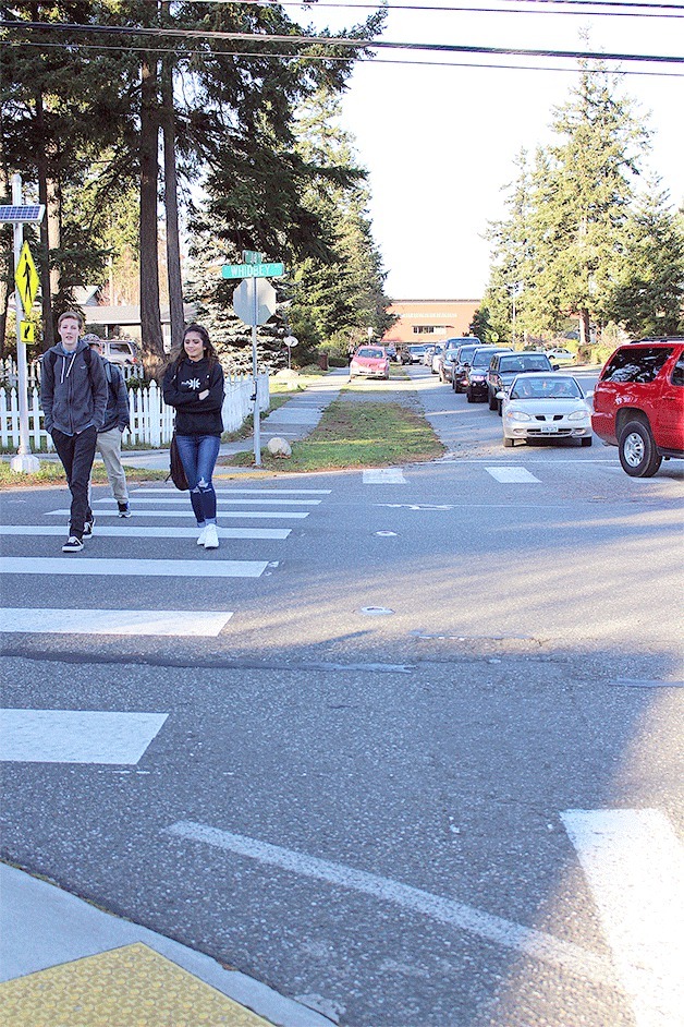 Oak Harbor High School Students cross Whidbey Avenue after school Friday afternoon. This is one crosswalk that features a button pedestrians can push that lights up signs and LED lights embedded in the street.