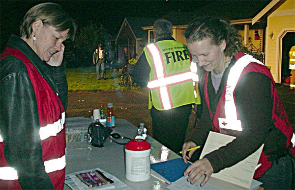 Red Cross Disaster Action Team volunteers Donita Crosby and Jessica Larson assist at a South Whidbey fire scene.