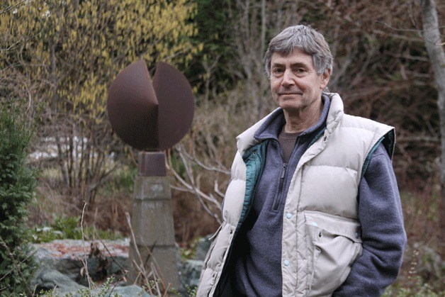 Oak Harbor abstract artist Richard Nash stands in his front yard near one of his sculptures. Nash's work is featured in the new book