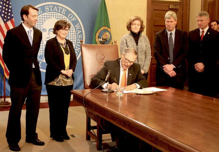 Gov. Jay Inslee (center) signs SB 6195