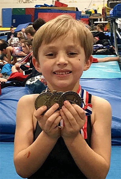 Ryder Chaffins shows off his three gold medals from the state trampoline and tumbling championships.