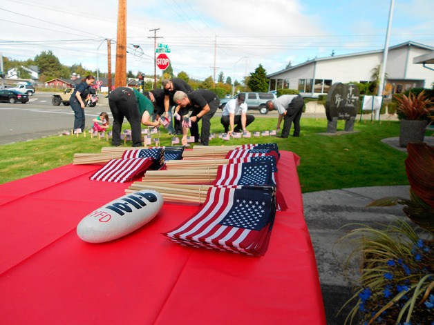 Volunteers place flags on Burley Funeral Chapel’s lawn last Saturday to honor the 2