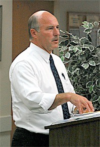 Oak Harbor City Administrator Paul Schmidt briefs the City Council on the need to increase its contract amount with a Bellingham law firm for work concerning sidewalk easements.
