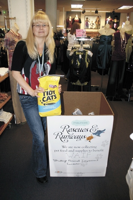 Organizer Linda Roberts shows off one of the donations made to WAIF for “Rescues and Runways.”