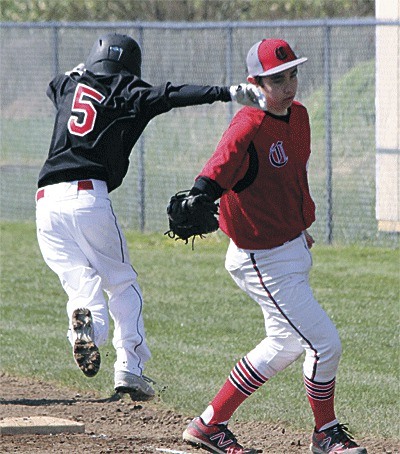 Port Townsend's Joe Hoffman tries to evade the tag of Coupeville first baseman Aaron Trumbull.