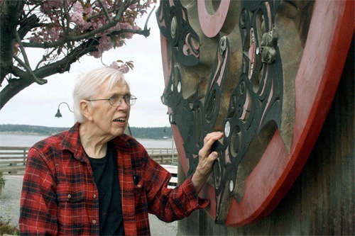 Coupeville woodworker Roger Purdue stands next to the salmon wheel he spent years carving in the 1990s. He designed the whale wheel that will be unveiled during the Penn Cove Water Festival May 14.