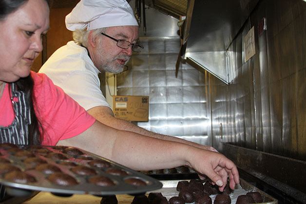 Valerie White and Patrick Christensen work on mochaccino muffins at the Knights of Columbus kitchen in Oak Harbor.