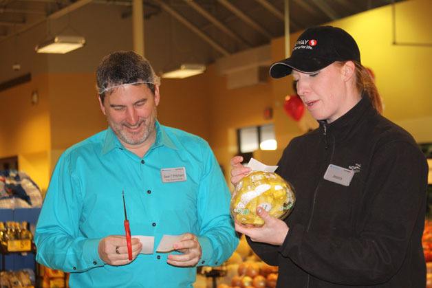 Safeway employees stick labels on items Friday morning shortly after the store opened at its new Erie Street location formerly occupied by Albertsons.