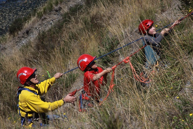 Volunteer firefighter Bill Brooks with North Whidbey Fire and Rescue helps two boys back up the bluff during a high-angle rescue after the brothers ventured into a steep area at Fort Ebey State Park. The boys were uninjured