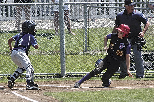 North Whidbey's Ethan Abbott slide home for a run in Sunday's first game.