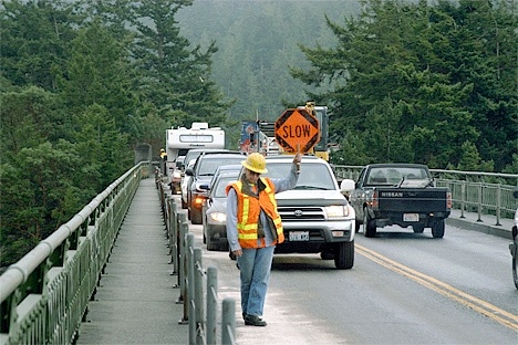 Washington State Department of Transportation worker Katherine Rogers directs traffic as a car accident is cleared at the Deception Pass Bridge.