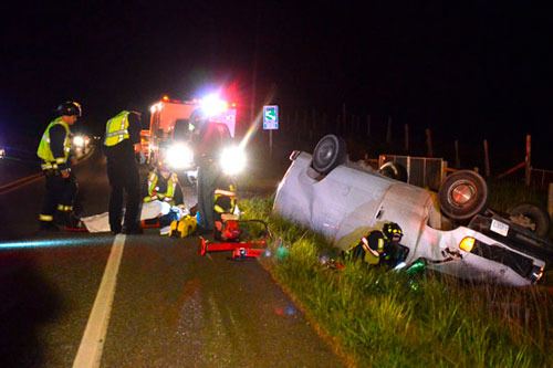 Central Whidbey Fire and Rescue firefighters help Coupeville resident Jon Vidoni Wednesday evening after he lost control of his van on Highway 20. He was transported to the hospital with what officers said appeared to be minor injuries.