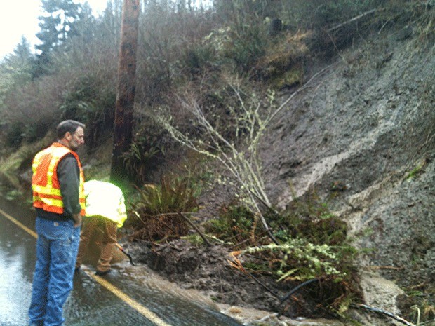 Employees with the Island County Public Works Department work to clear a mudslide on North Bluff Road in Central Whidbey Thursday.