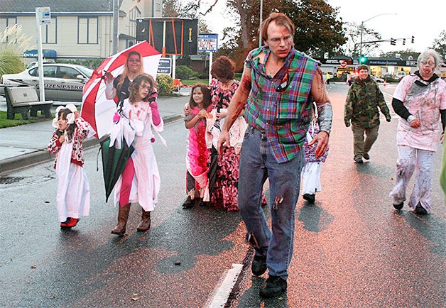 A group of “die hard” zombies begin their crawl along Midway Boulevard in the wind and rain at the start of this year’s Monster Mash Street Bash and Zombie Crawl.