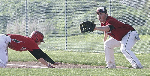 Coupeville's Ben Etzell dives safely back to first as Cedarcrest's Colton Sandhofer awaits the pickoff throw.