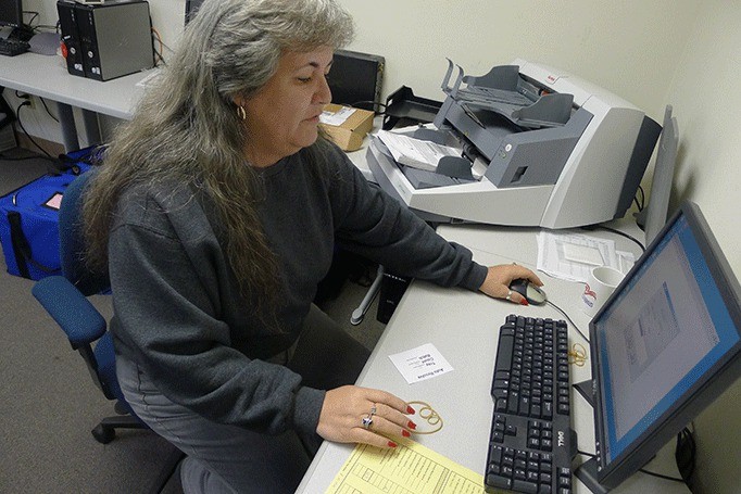 Island County deputy auditor Michele Reagan scans ballots the office received for a special election concerning two Coupeville School District levies. The ballots had to be either postmarked or received by the auditor’s office Tuesday.