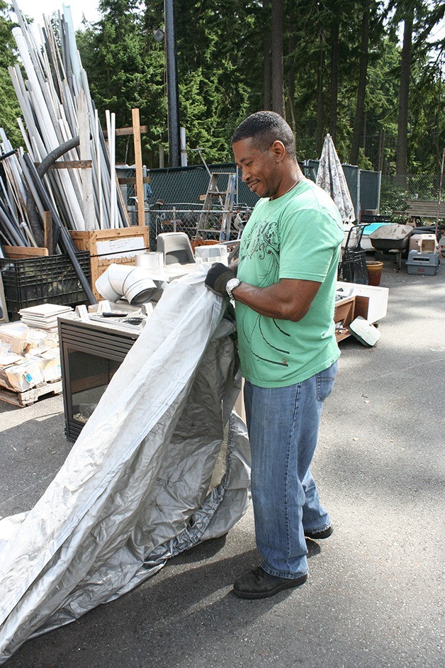 Barc Re-tail volunteer Richard Stroter folds a tarp last week as he assisted residents who donated items to the organization
