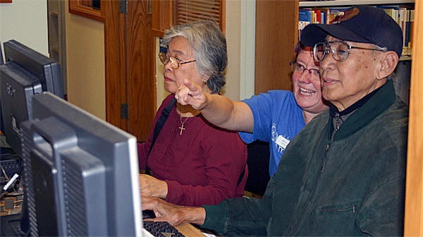 Moises and Delia Pardo practice computer basics with librarian Anne Murphy.