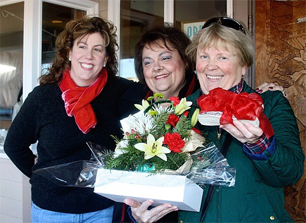 Bayleaf owner Beth Graves and Janice Vaughan of Whidbey Island Bank stand with Red Ticket award winner Mary Hollen