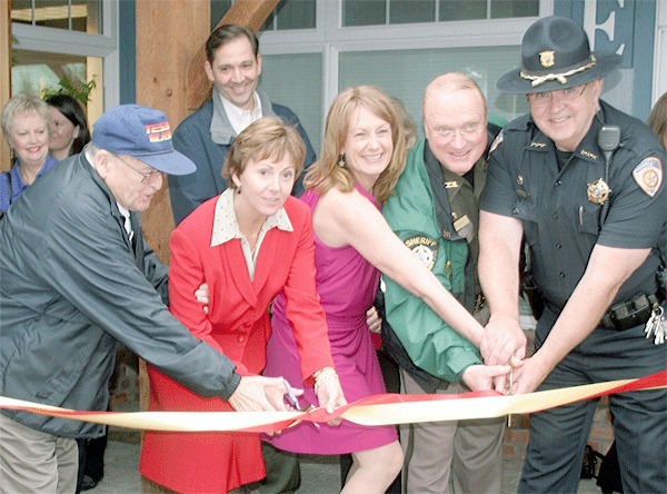 The ribbon is cut Wednesday evening for the official opening of the new headquarters of the Whidbey News-Times and South Whidbey Record in Coupeville. Sharing the honors at the ribbon are