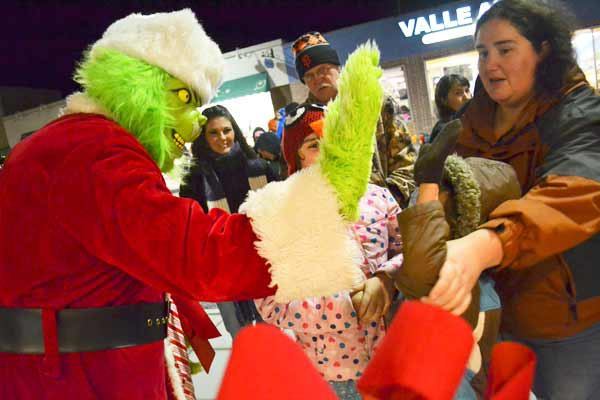 The Grinch came to entertain children waiting in line to visit Santa Claus after the tree lighing in downtown Oak Harbor. The line stretched from the inside of the building to across the street. Stores on Pioneer Way stayed open later so community members could get a start on their holiday shopping.