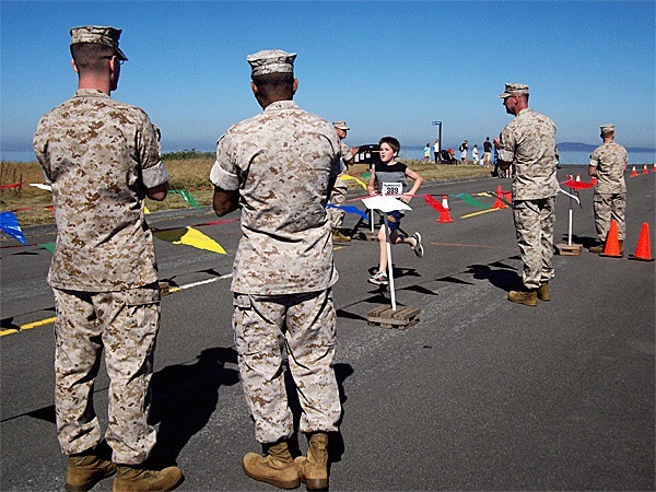 Marines stand by the finish line clapping for finishers of the race that honored McClung who was killed while serving in Iraq.  The race