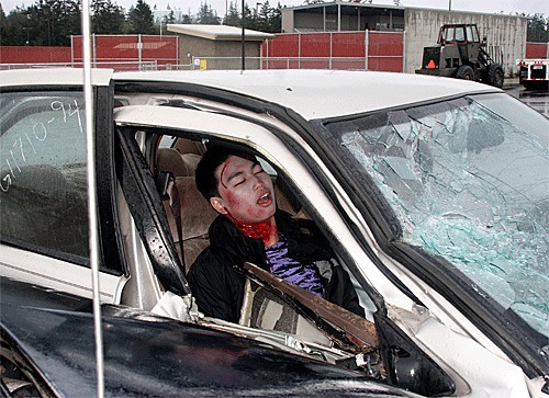 Senior Andrew DeLeon pretends to be unconscious and injured after a faux DUI accident at Oak Harbor High School. The “accident” was part of an educational assembly encouraging safe decisions.