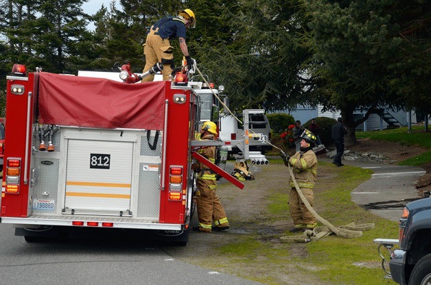 Firefighters with the Oak Harbor Fire Department and Navy Region Northwest Fire and Emergency Services respond to a kitchen fire in Oak Harbor Wednesday.