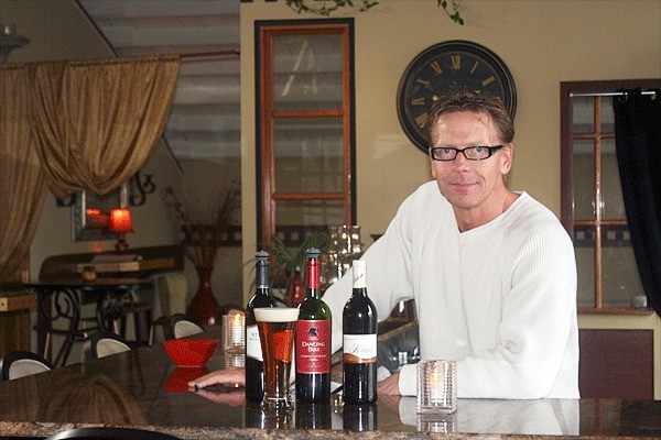 Brian Montana stands behind the bar of The Terrace Wine Bar & Bistro