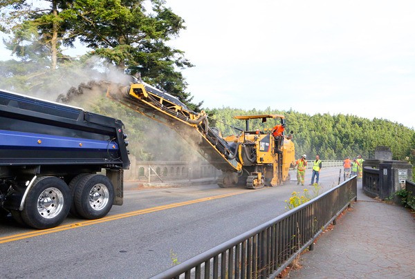 Contractors grind off the asphalt on Deception and Canoe Pass bridges on Sunday night