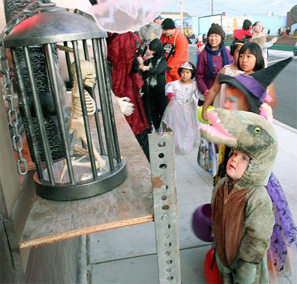 Three-year-old Dorian Dollarhyde pauses to check out the spooky decor on Pioneer Way.