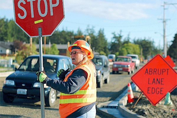 GG Excavation flagger Ronalda Mehlum waves traffic through the intersection of N. Oak Harbor Road and Whidbey Avenue. The $1.54 million street project