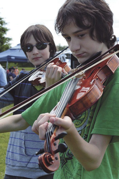 Avrey and Dustin (right) Scharwat play their violins at the Coupeville Farmers Market. The fraternal twins also hold junior black belts in Karate.