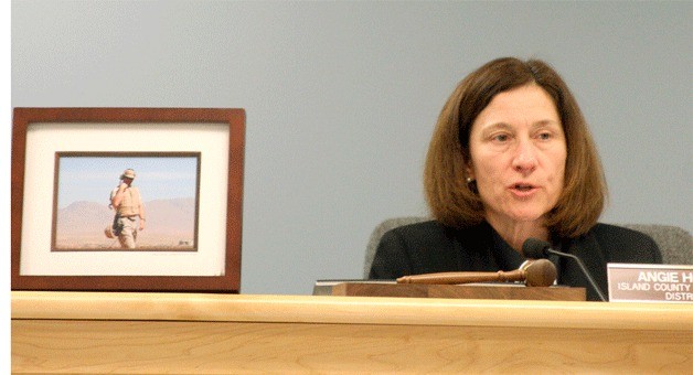 Commissioner Angie Homola uses a picture of her husband to demonstrate her ties to the Navy.