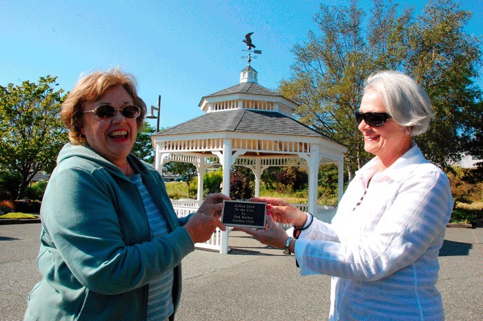 Oak Harbor Garden Club members Claire Reed and Judy Biddle hold up a placard that will be installed on the new gazebo at Hal Ramaley Park. The club is gifting the structure to the city and a dedication ceremony is planned for Aug. 24.