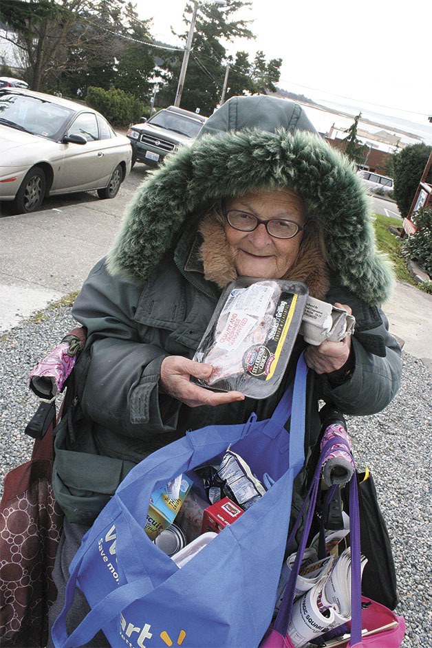 Monte Parker shows items from her monthly “food basket” from the North Whidbey Help House